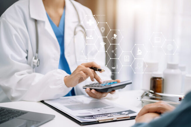資料を見ながら電卓を操作する女性医師