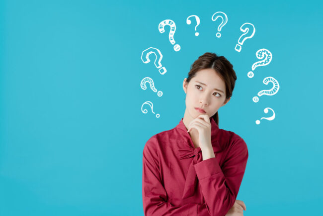 顎に手を当てて考える赤い服の女性