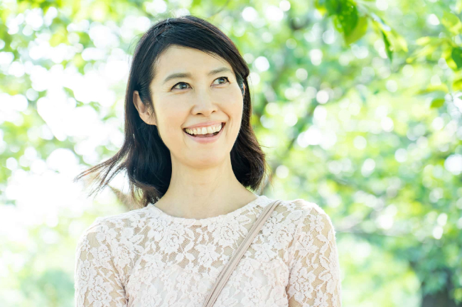 ホワイトニングをした白い歯で散歩を楽しむ女性