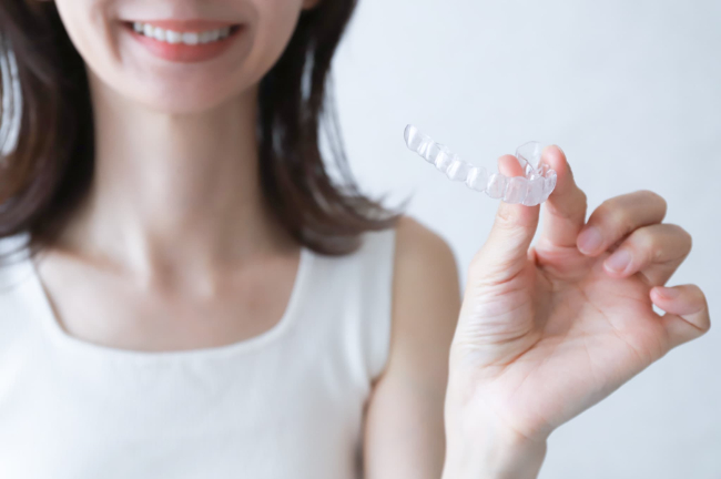 マウスピースを持って微笑む女性