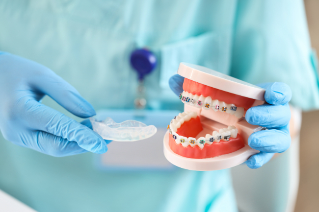 ワイヤー矯正とマウスピース矯正の費用を説明する歯科医師