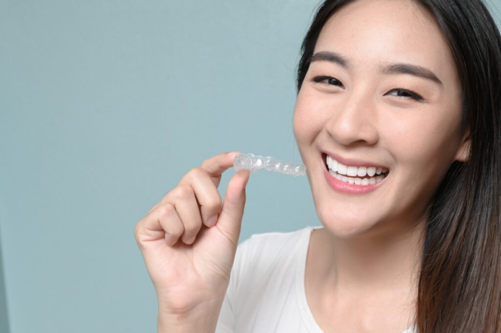 マウスピースを手に持った笑顔の女性
